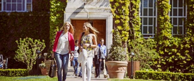 Study Students walking in front of the University entrance